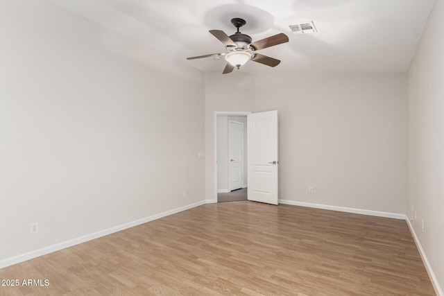 spare room featuring light wood-style flooring, visible vents, ceiling fan, and baseboards