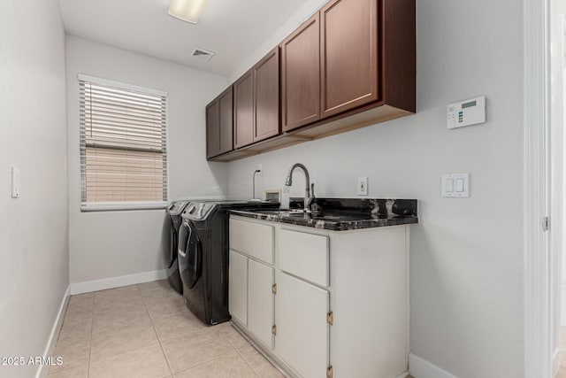 washroom featuring washer and clothes dryer, cabinet space, visible vents, light tile patterned flooring, and a sink