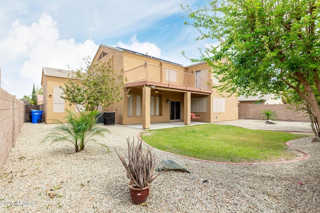 back of house featuring a fenced backyard, a lawn, a patio, and stucco siding