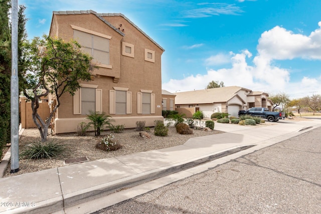 view of front of house featuring fence and stucco siding