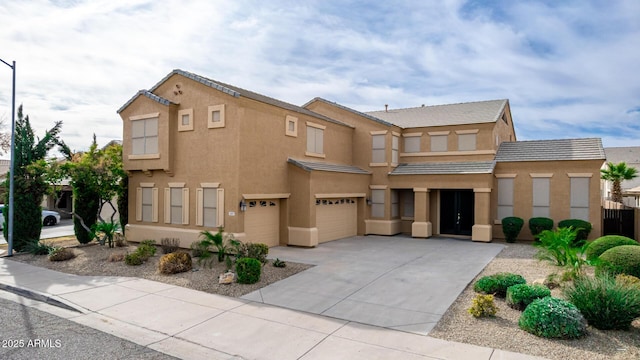 view of property featuring driveway, a tile roof, an attached garage, fence, and stucco siding