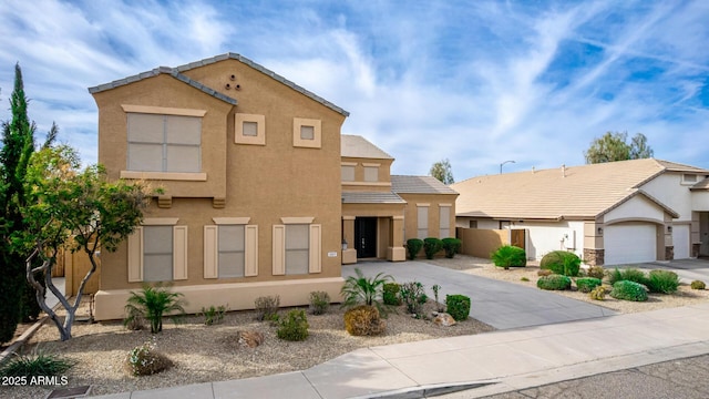 view of front of house with driveway, a tiled roof, fence, and stucco siding