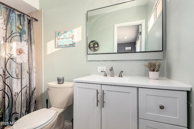 bathroom featuring toilet, a shower with shower curtain, and vanity
