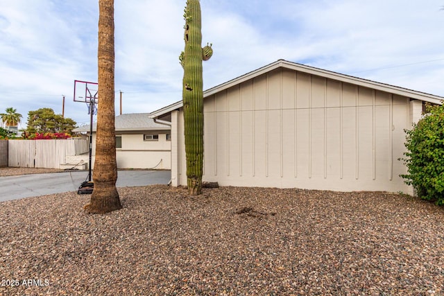 view of side of home featuring fence