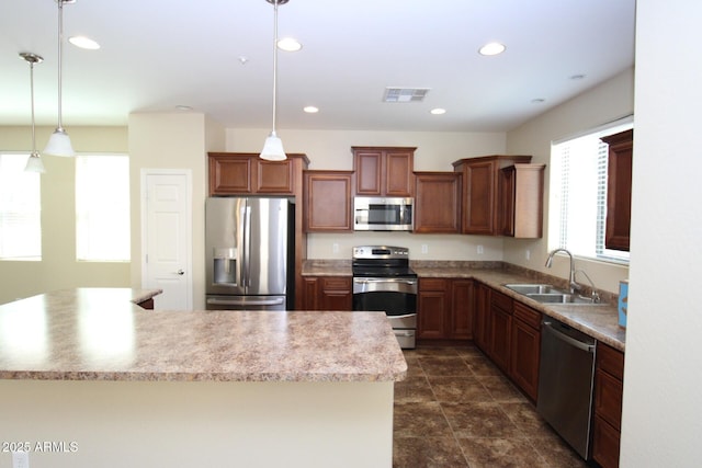 kitchen with stainless steel appliances, a kitchen island, sink, and decorative light fixtures