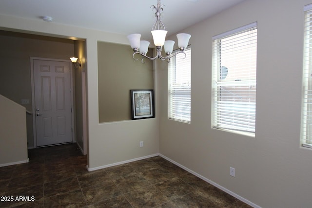 spare room with a notable chandelier