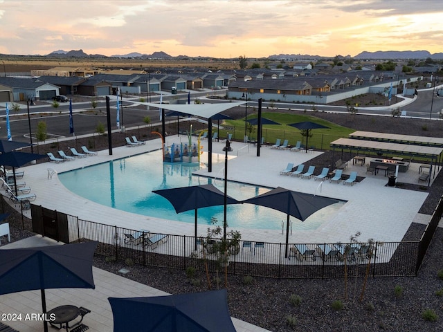 pool with a patio area, fence, and a residential view