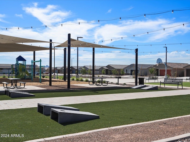 view of community featuring playground community, a yard, and a residential view