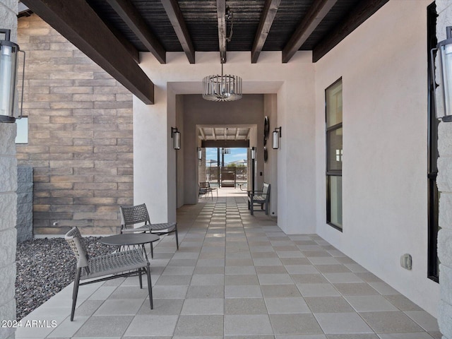 doorway to property featuring stone siding, a patio area, and stucco siding