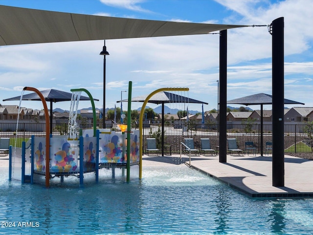 community pool with fence and a water play area