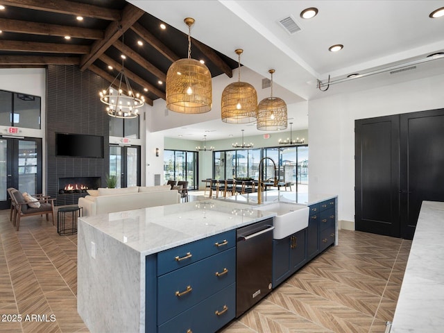 kitchen with a notable chandelier, open floor plan, blue cabinetry, a center island, and decorative light fixtures