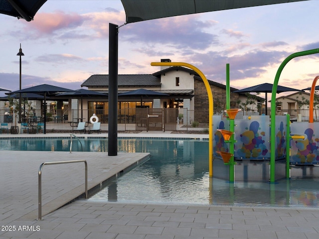 pool featuring fence, a water play area, and a patio