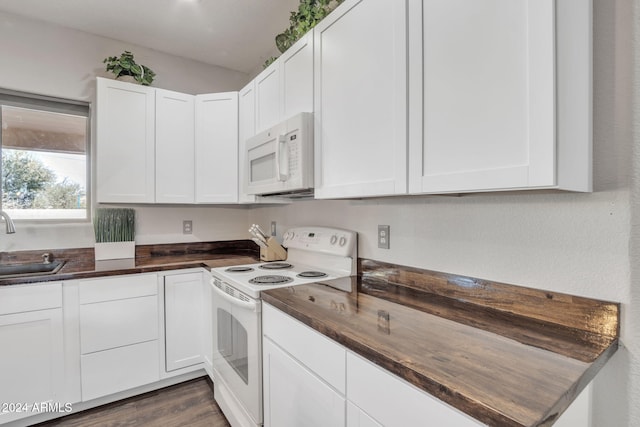 kitchen with white appliances, dark hardwood / wood-style floors, white cabinetry, and sink