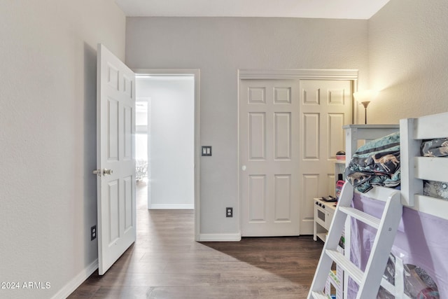 bedroom with dark hardwood / wood-style flooring and a closet