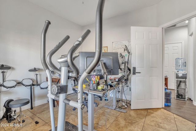 workout room featuring light hardwood / wood-style floors and vaulted ceiling