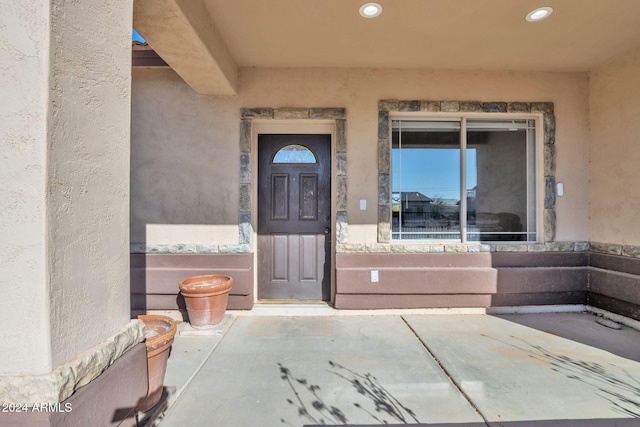 view of exterior entry with a patio