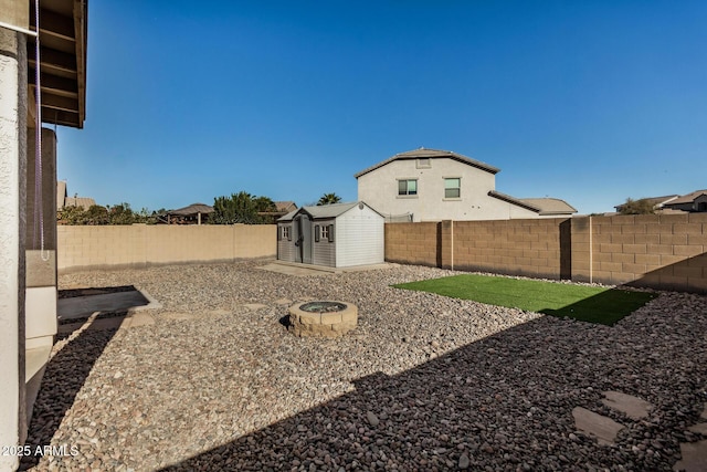 view of yard featuring a storage shed and a fire pit