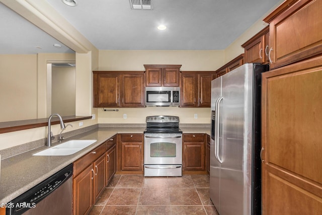 kitchen featuring stainless steel appliances, sink, and dark tile patterned floors