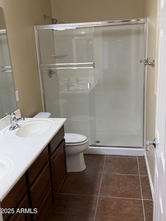 bathroom with a shower with door, vanity, tile patterned flooring, and toilet