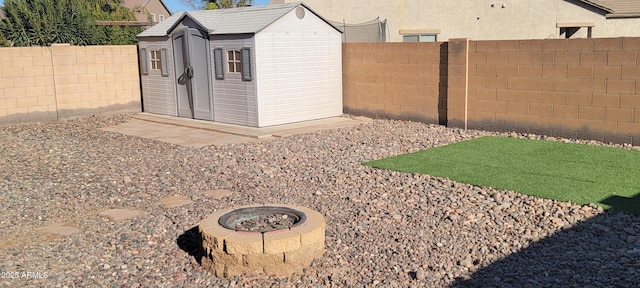 view of yard with a shed and a fire pit