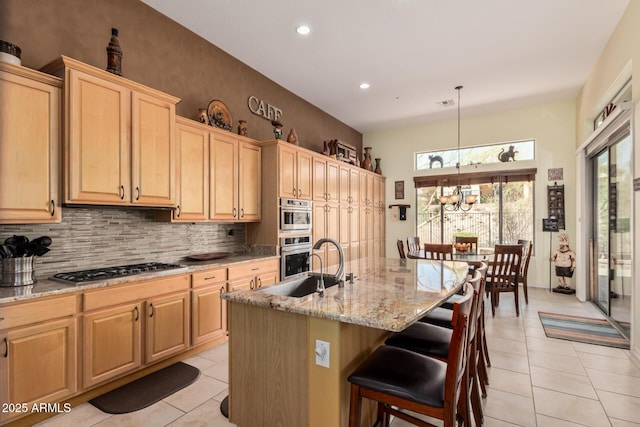 kitchen featuring light tile patterned floors, decorative backsplash, appliances with stainless steel finishes, light stone counters, and light brown cabinets