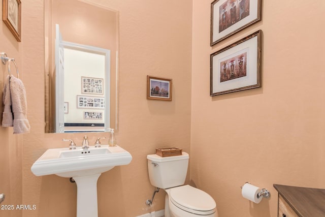 bathroom with toilet and baseboards