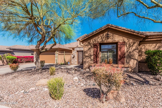 ranch-style house with driveway, an attached garage, and stucco siding