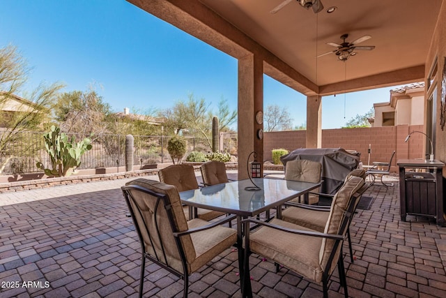 view of patio / terrace featuring outdoor dining space, grilling area, a fenced backyard, and a ceiling fan