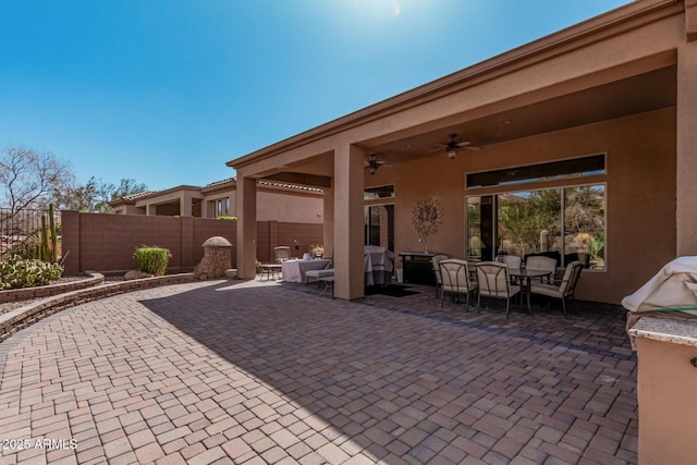 view of patio featuring outdoor dining area, fence, and ceiling fan