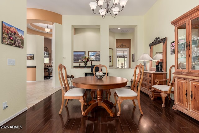 dining room with a chandelier, baseboards, and wood finished floors