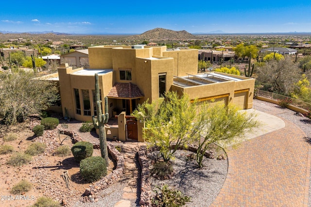 10657 E Cloudview Ave, Gold Canyon, AZ 85118 - adobe home featuring decorative driveway, an attached garage, a mountain view, and stucco siding