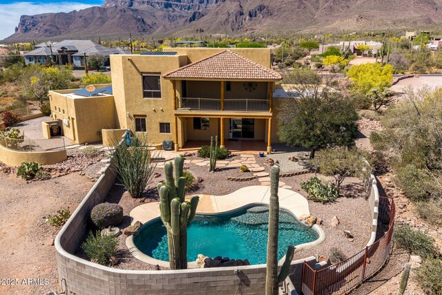 10657 E Cloudview Ave, Gold Canyon, AZ 85118 - back of house featuring a balcony, an outdoor pool, stucco siding, a patio area, and a mountain view
