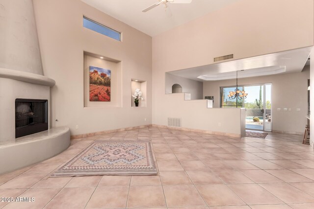 10657 E Cloudview Ave, Gold Canyon, AZ 85118 - unfurnished living room with visible vents, ceiling fan with notable chandelier, tile patterned flooring, and a large fireplace