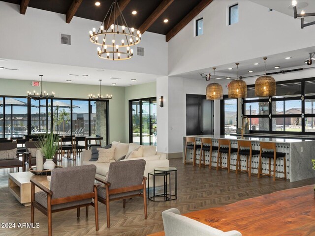 dining space with beam ceiling, parquet flooring, high vaulted ceiling, and a chandelier