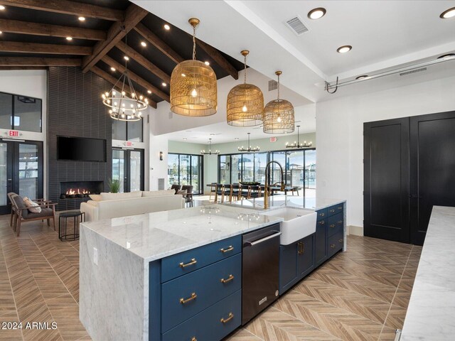 kitchen with blue cabinetry, dishwasher, high vaulted ceiling, decorative light fixtures, and a kitchen island