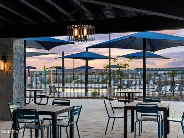 dining space with a chandelier and vaulted ceiling with beams