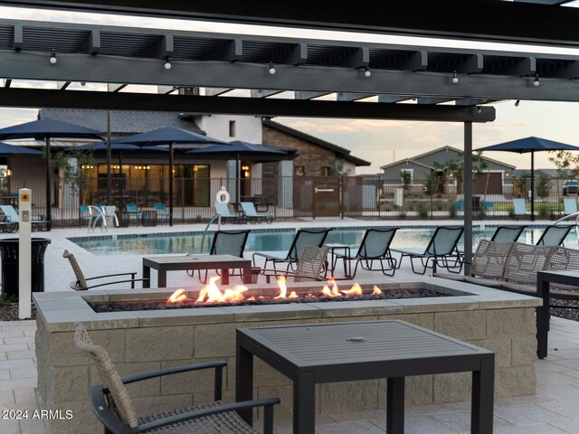 view of swimming pool with a patio area and an outdoor fire pit