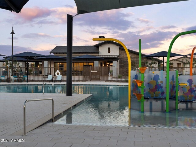 pool at dusk featuring a patio