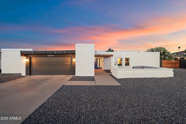 contemporary house with a garage, driveway, and stucco siding