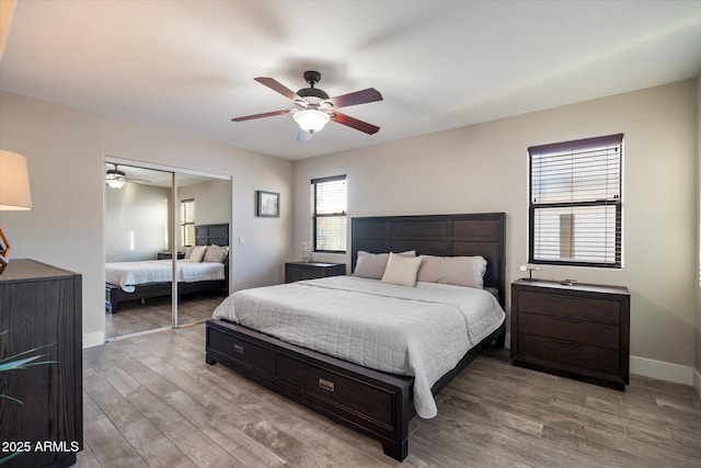 bedroom with light wood-style floors, a closet, baseboards, and a ceiling fan
