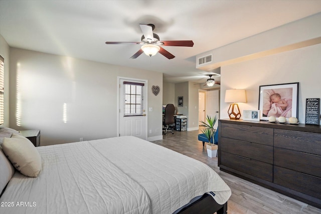 bedroom featuring light wood-style floors, a ceiling fan, and baseboards