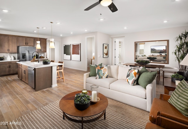 living room with ceiling fan and sink