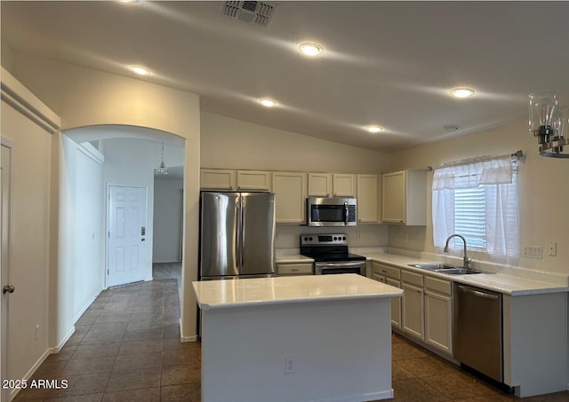 kitchen with vaulted ceiling, sink, a center island, white cabinetry, and stainless steel appliances