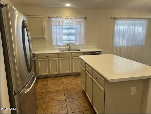 kitchen featuring sink, stainless steel fridge, and a center island