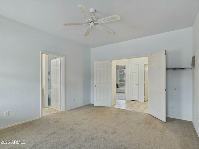 unfurnished bedroom with carpet, tile patterned flooring, connected bathroom, and baseboards