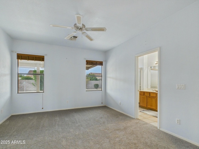 unfurnished bedroom featuring light carpet, multiple windows, visible vents, and connected bathroom