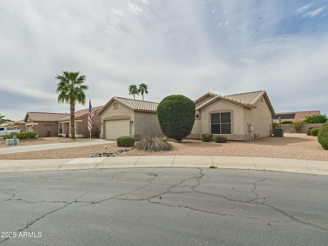 view of front of property featuring a garage, driveway, a tiled roof, and stucco siding