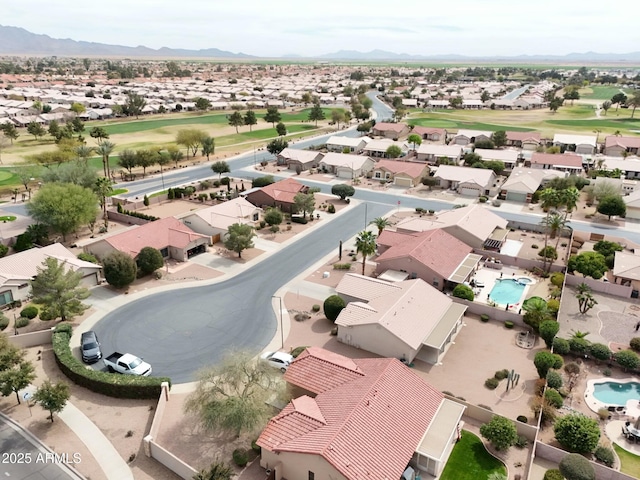 drone / aerial view featuring a mountain view, view of golf course, and a residential view