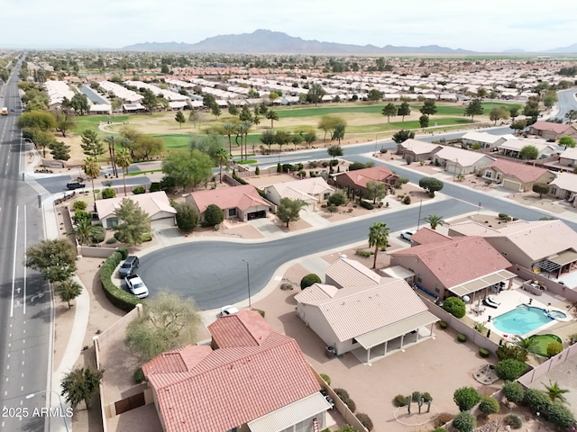 drone / aerial view featuring view of golf course, a residential view, and a mountain view