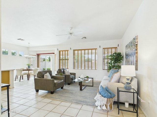 living room with ceiling fan with notable chandelier, visible vents, and light tile patterned flooring